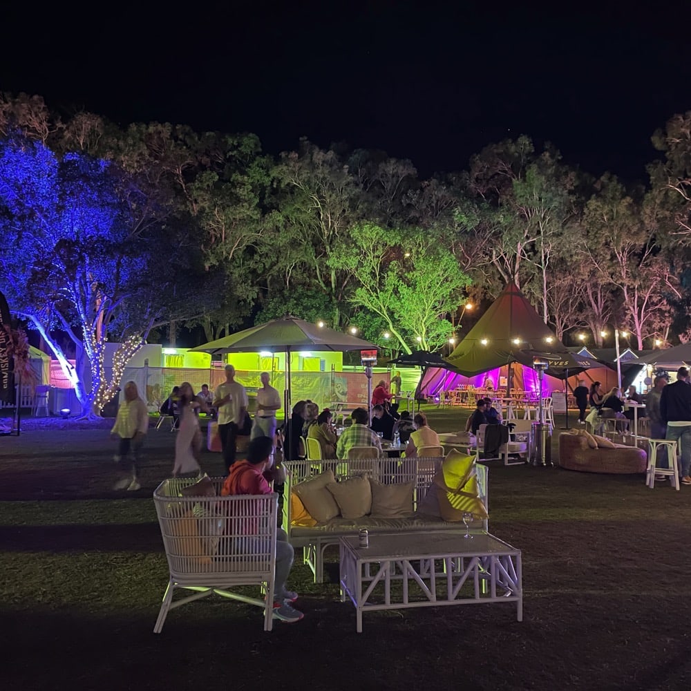 Moreton bay food and wine festival. People sitting in outdoor seating. Trees with lights are in the background. Live event audio Brisbane, Gold Coast, Sunshine Coast