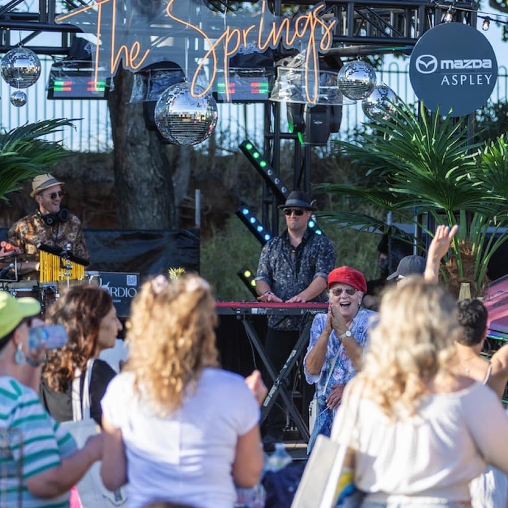 Man stands on stage in front of crowd. Live event audio Brisbane, Gold Coast, Sunshine Coast